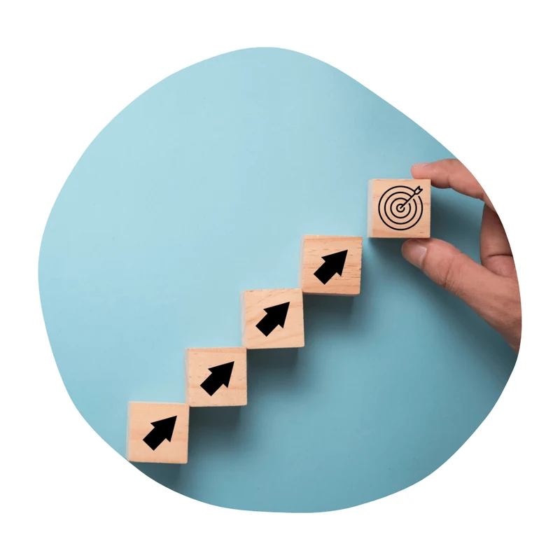 Wooden blocks rising in a staircase pattern toward a target — stylised illustration of progressive learning.